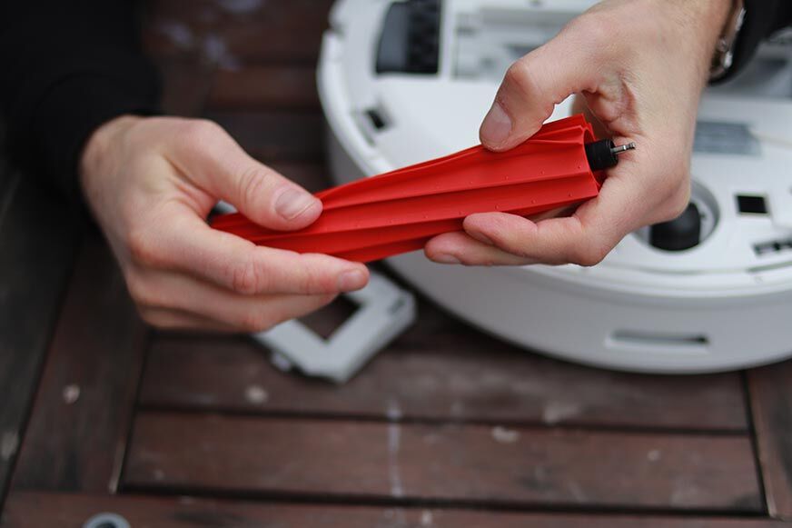 Die Gummibürste des Roborock Q7 Max Plus wird in den Händen gehalten